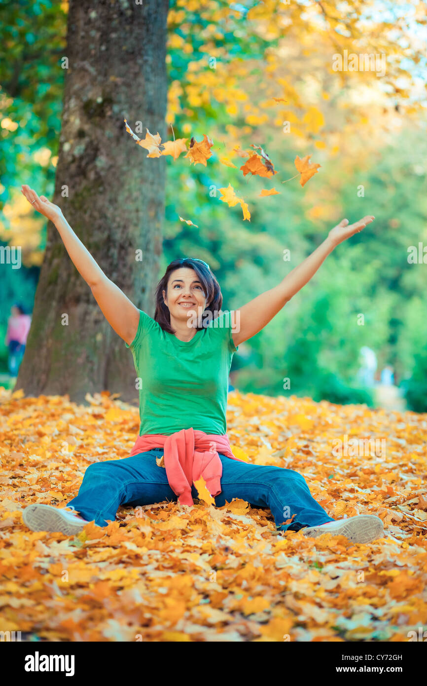 Nice girl playing with autumn falling leaves in the park Stock Photo ...