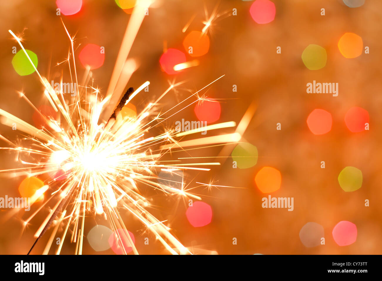 Sparkler and colorful bokeh christmas new year background Stock Photo