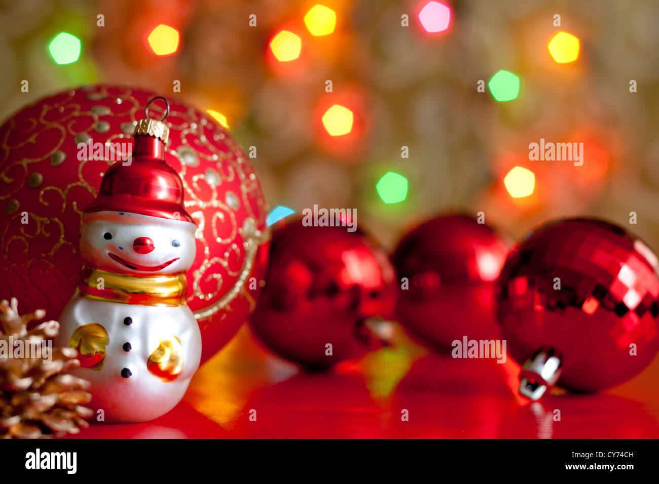 Snow man and baubles against blurred colorful background Stock Photo