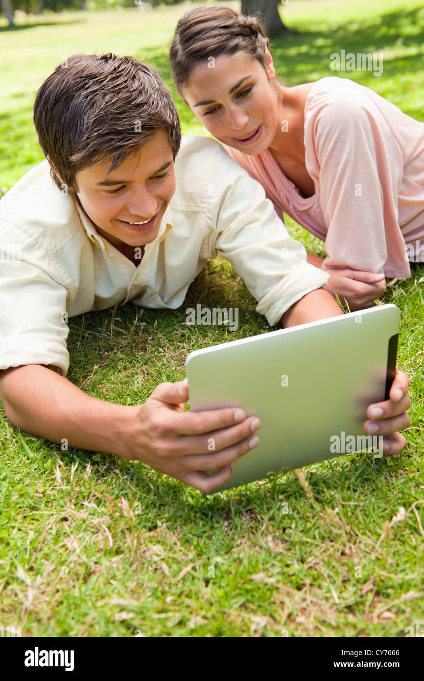 Two friends smiling as they watch something on a tablet together Stock Photo