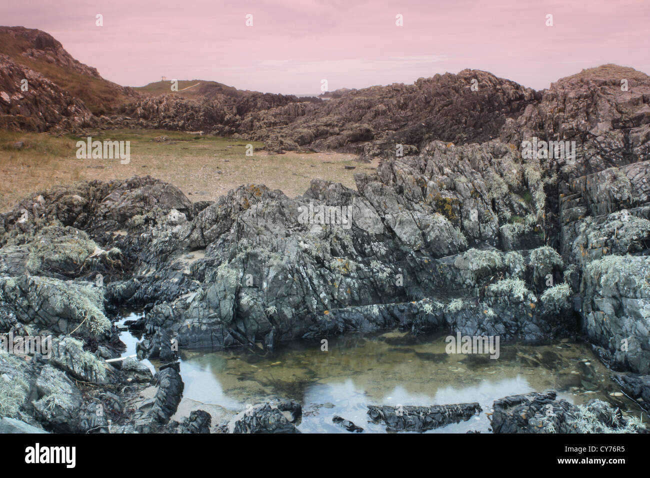 Lava rocks and lighthouse on Llanddwyn Island Anglesey Stock Photo