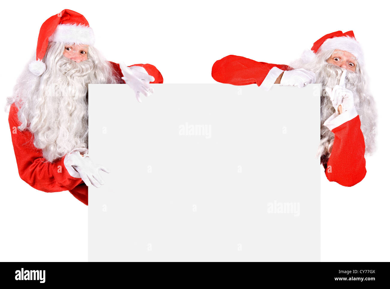 Two Santa Claus holding a blank sign Stock Photo - Alamy