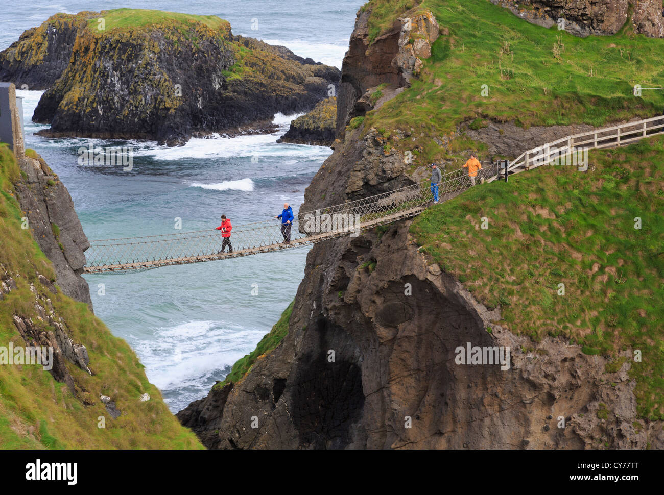 People walking on Carrick-a-Rede Rope Bridge from Carrick Island