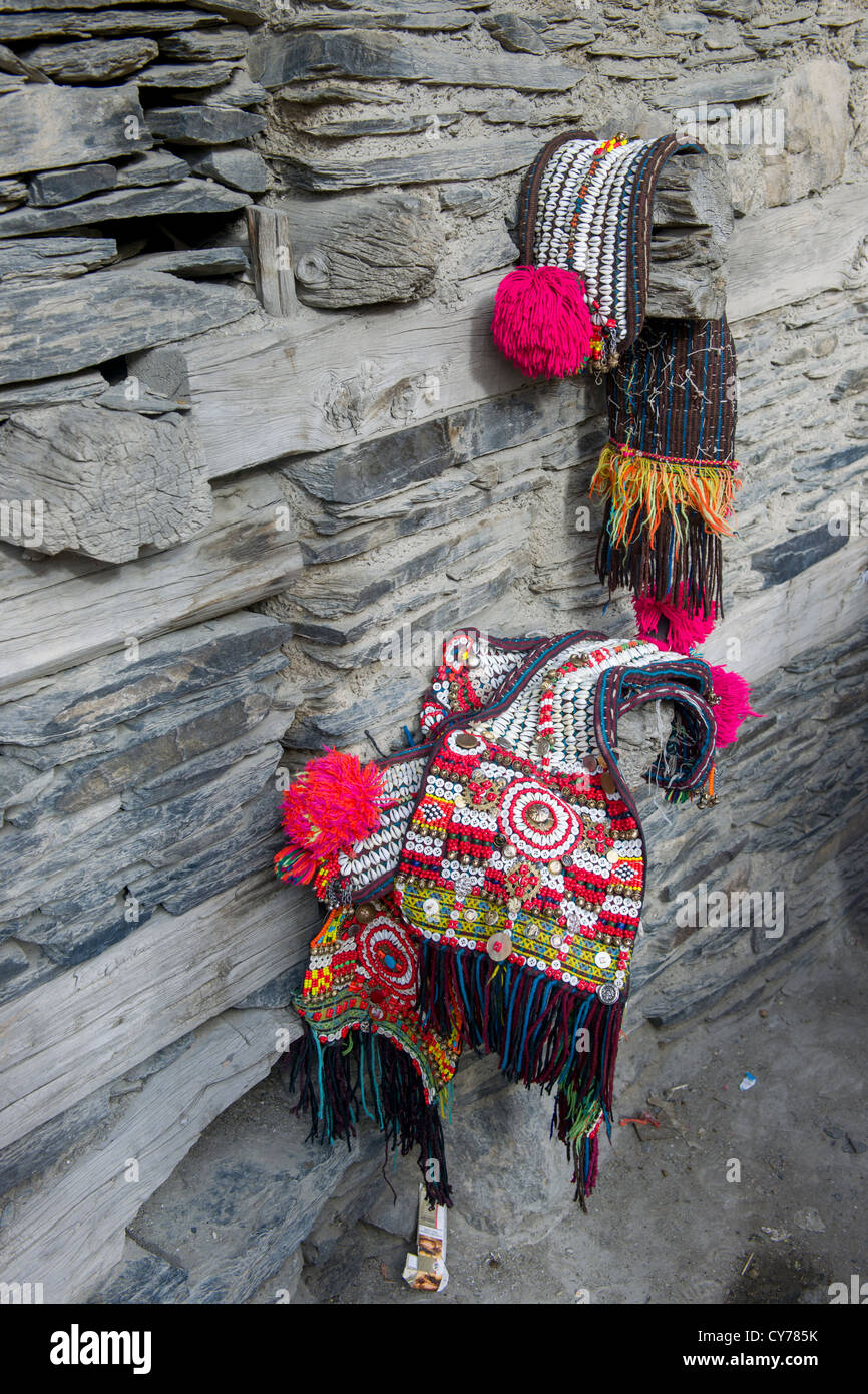 Kalash cowrie shell headdresses (shushut) hanging on a wall at the Grum Village Charso (dancing ground), Kalash Joshi (Spring Festival), Rumbur Valley, Chitral, Khyber-Pakhtunkhwa, Pakistan Stock Photo