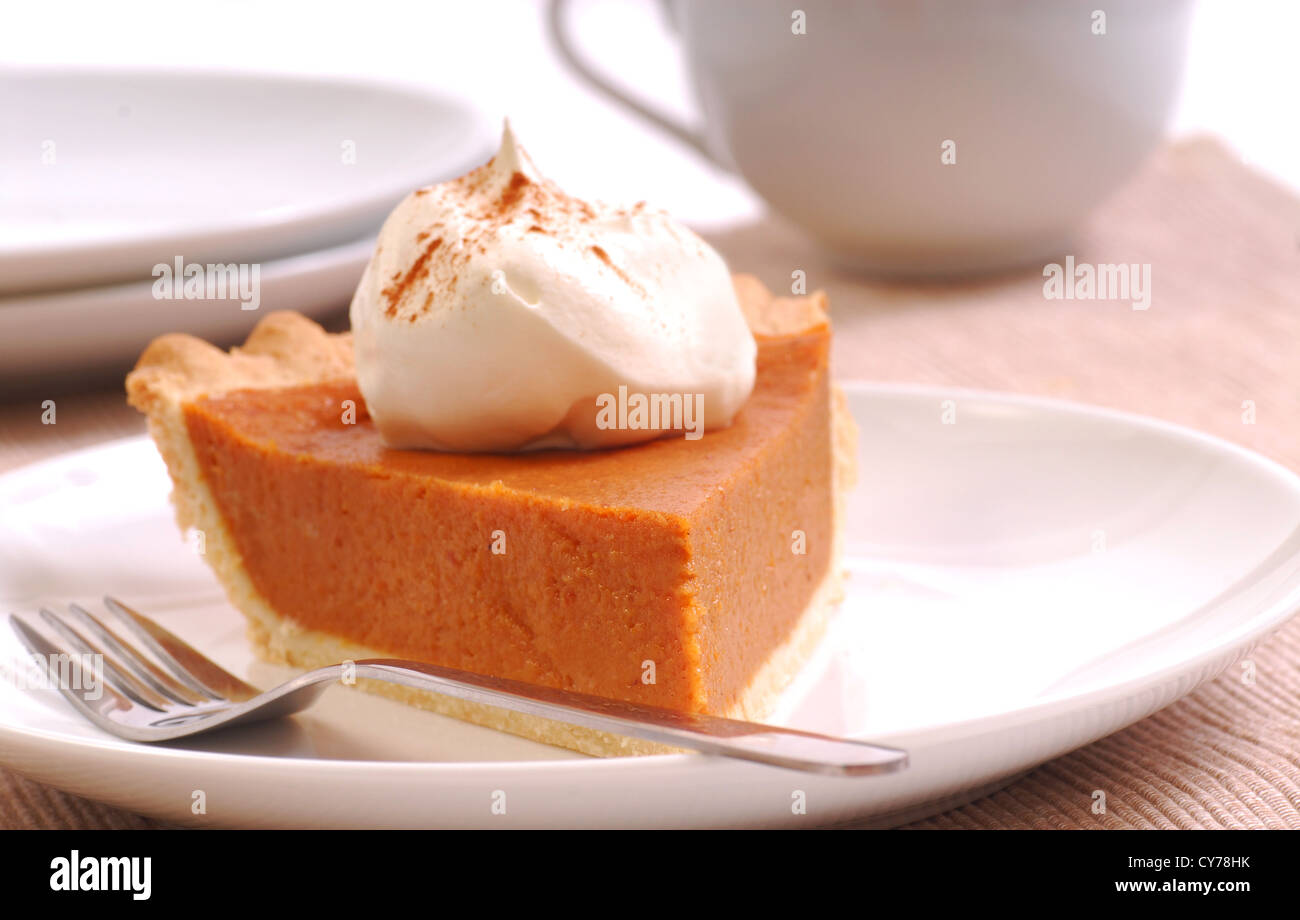 Slice of freshly made pumpkin pie with whipped cream and cinnamon Stock Photo