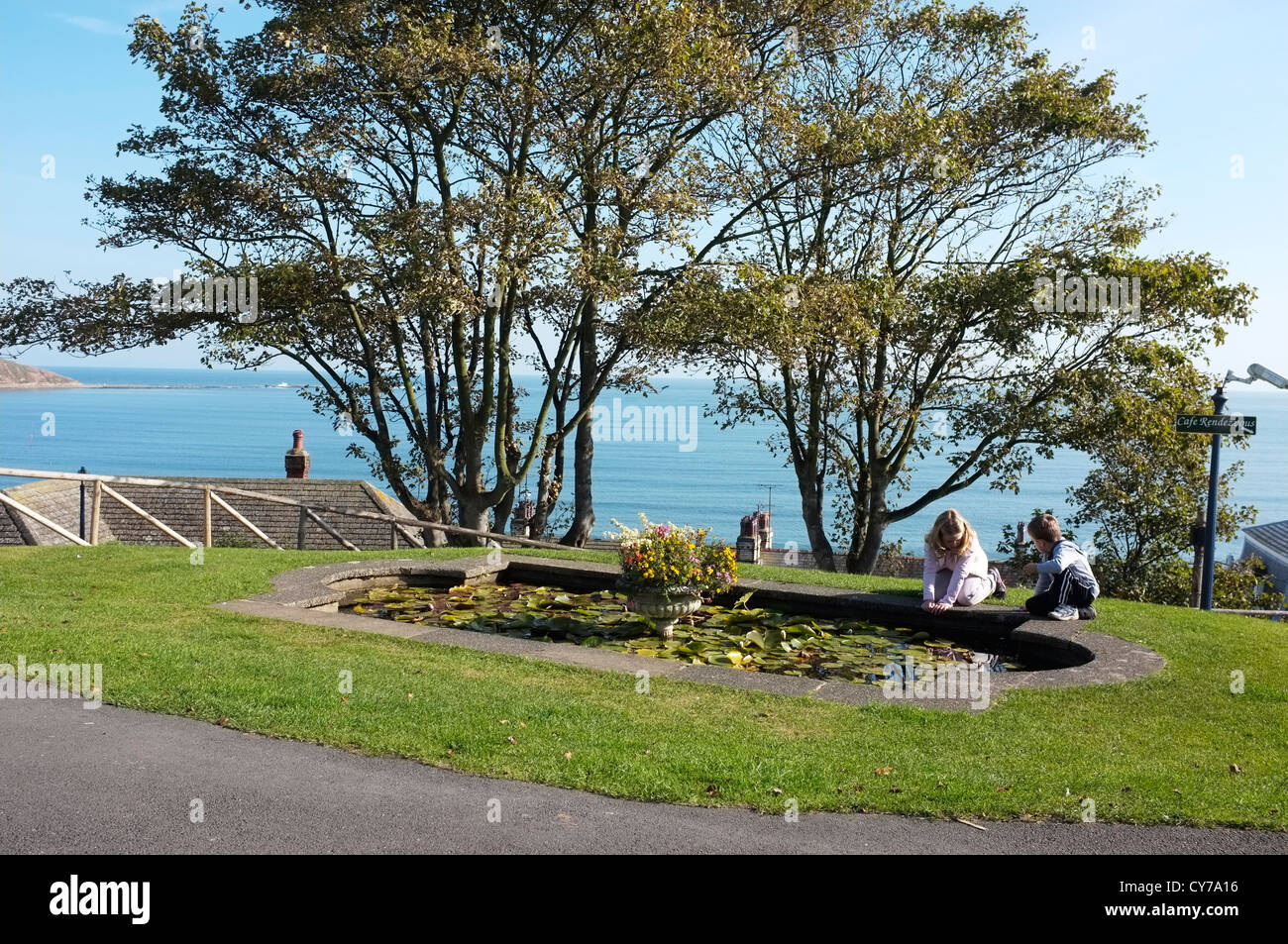 Children playing by a Lily pond on the cliff top at Filey, Yorkshire. Stock Photo