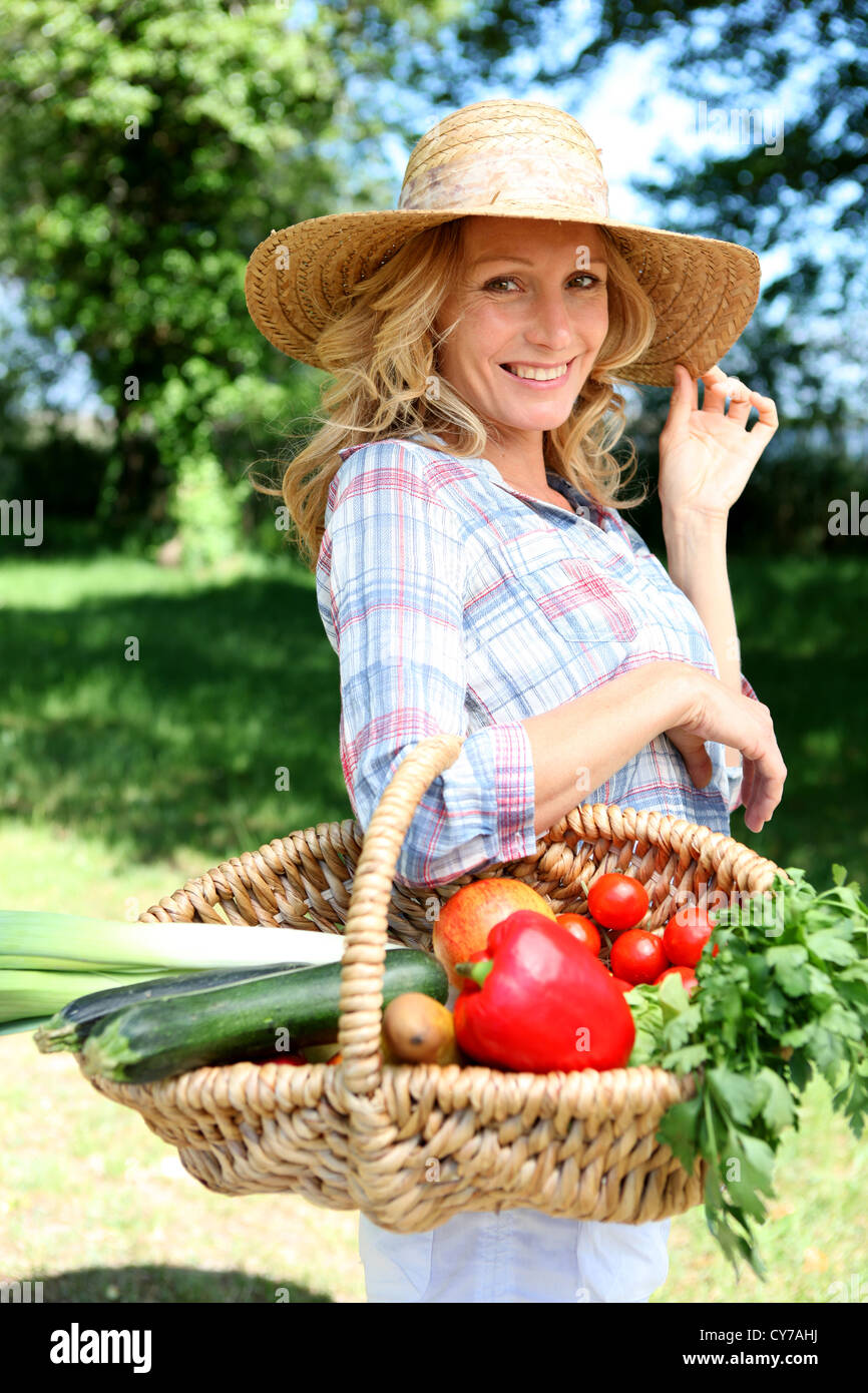 Pretty woman with a straw hat and basket of vegetables Stock Photo - Alamy