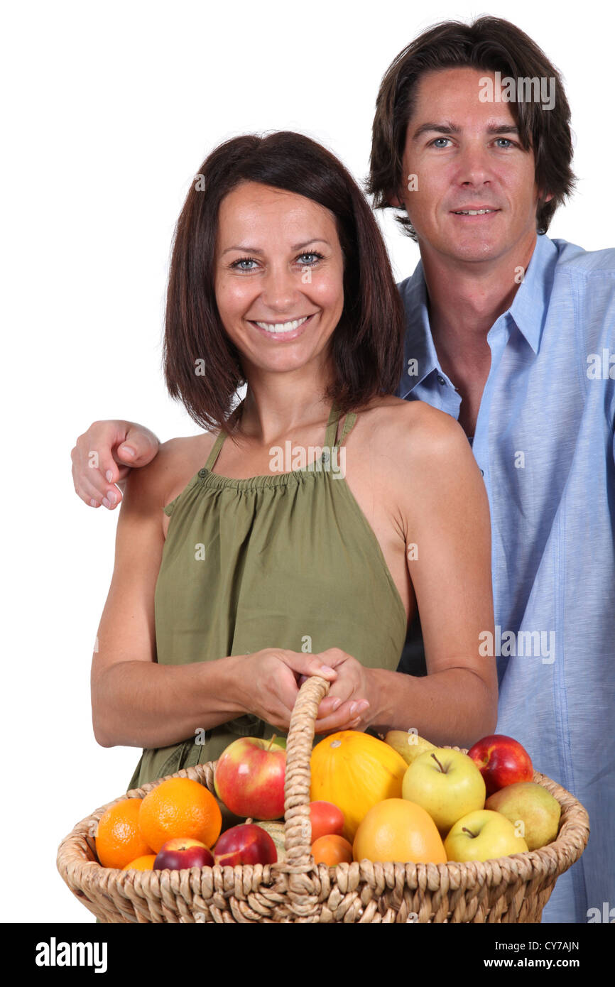 Man and woman with a basket of fruit Stock Photo - Alamy