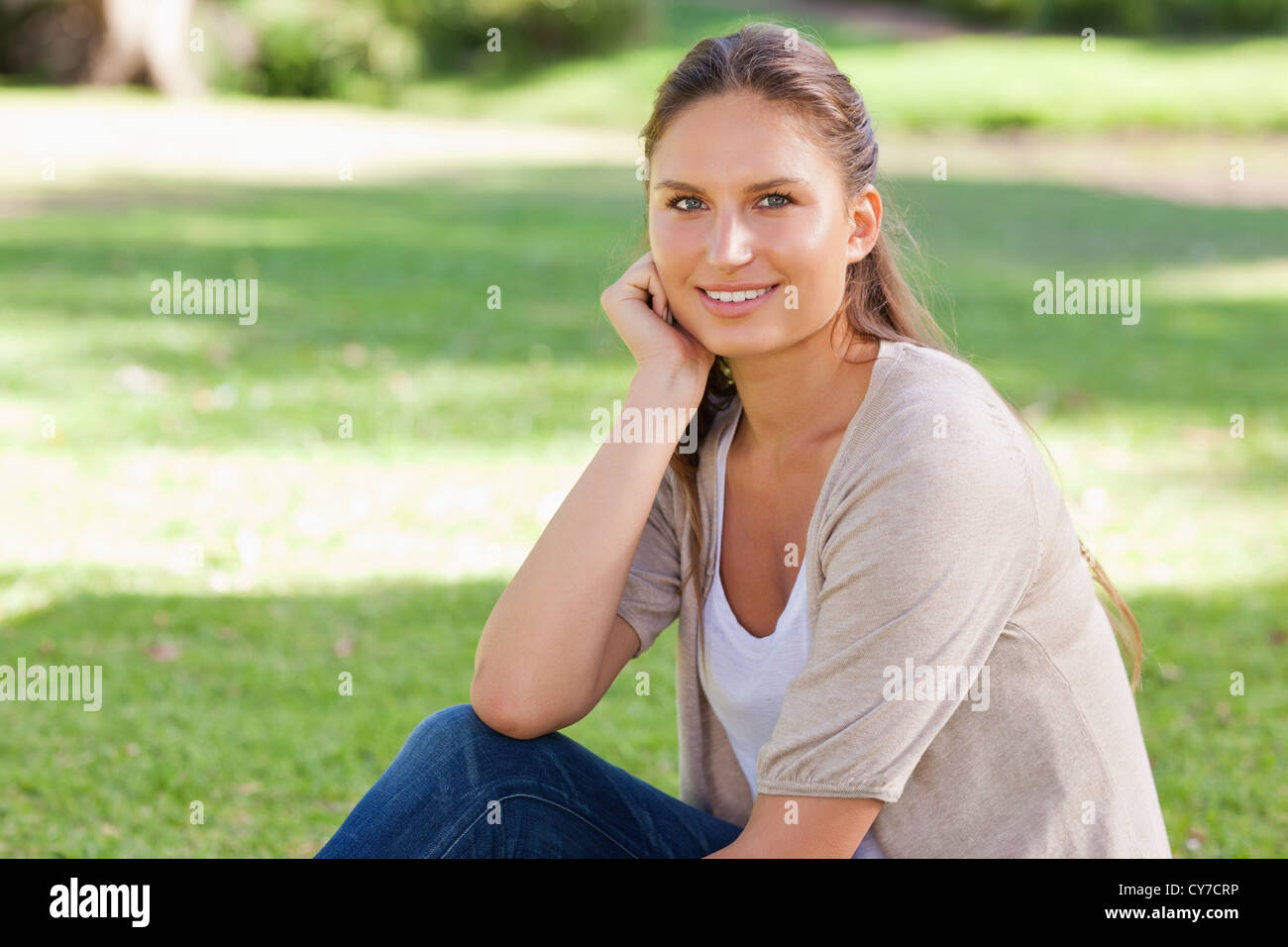Relaxed woman sitting on the lawn Stock Photo - Alamy