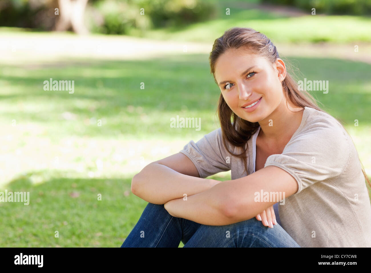 Smiling woman relaxing in the park Stock Photo - Alamy