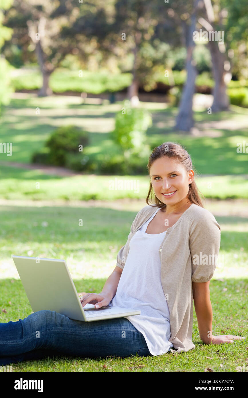 Smiling woman with her notebook in the park Stock Photo - Alamy