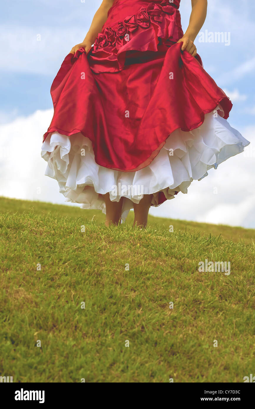 a woman in a red dress on a meadow Stock Photo - Alamy