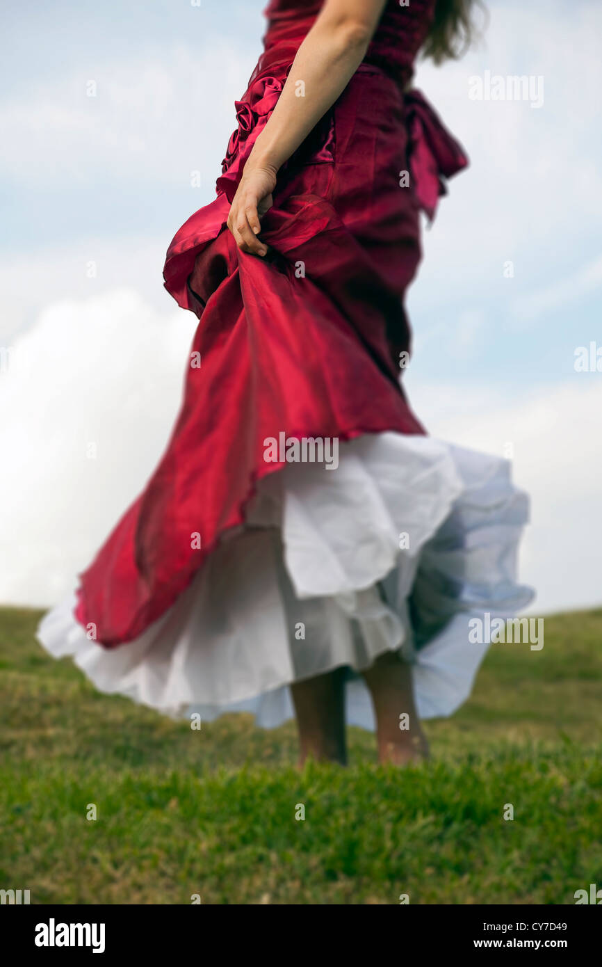 a woman in a red dress on a meadow Stock Photo