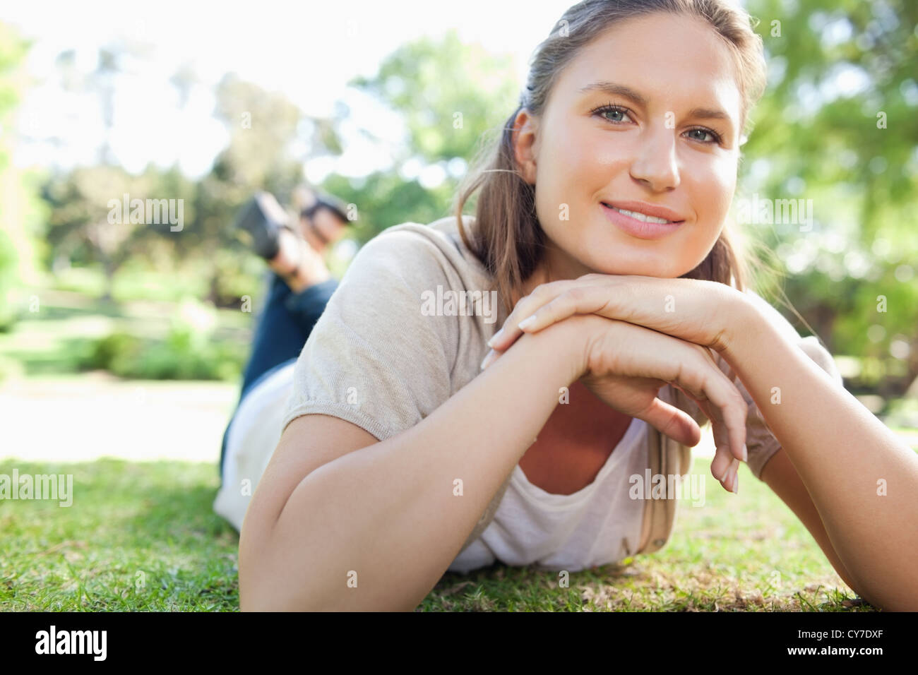 Smiling woman laying on the lawn Stock Photo - Alamy