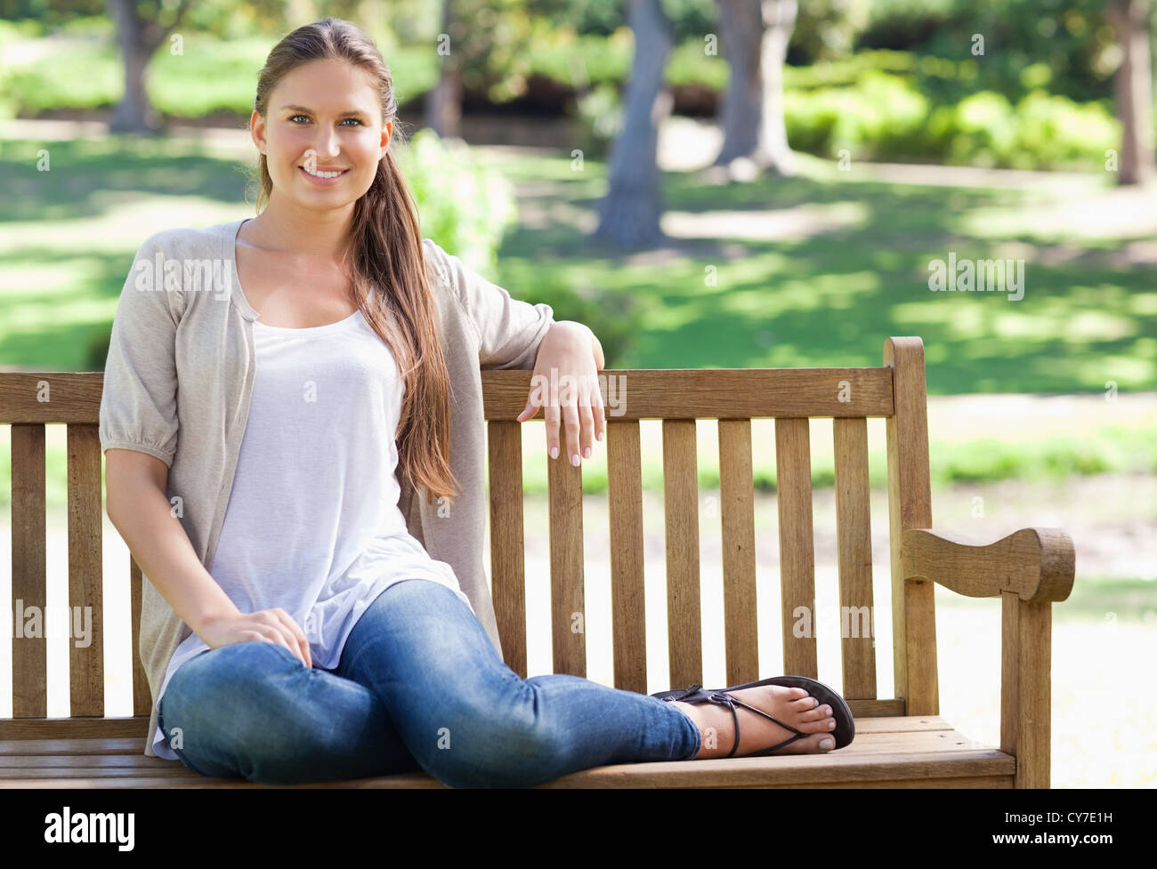Woman sitting on a bench in the park Stock Photo - Alamy