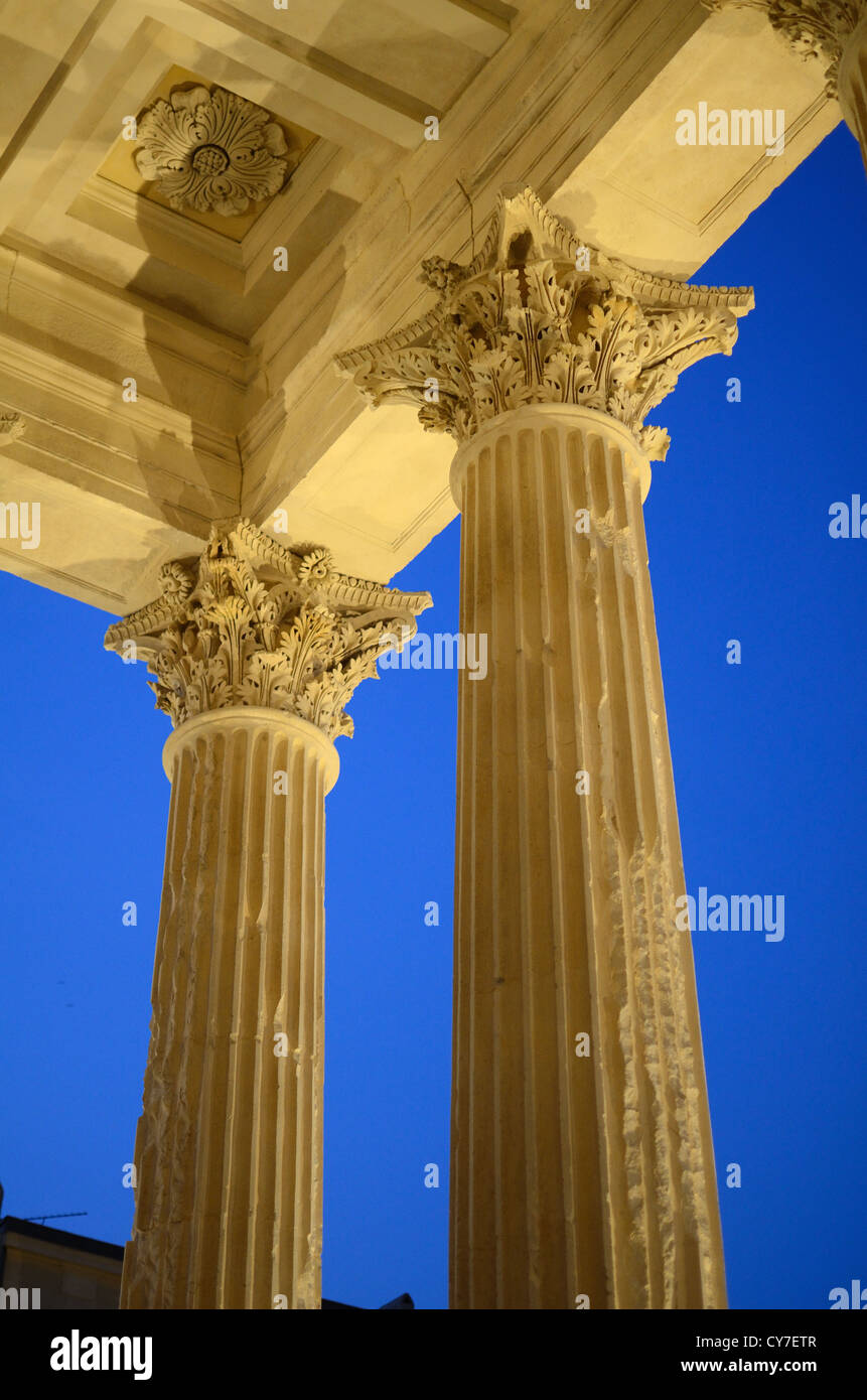Corinthian Columns of the Maison Carrée or Roman Temple at Nimes Lit at Night Gard France Stock Photo