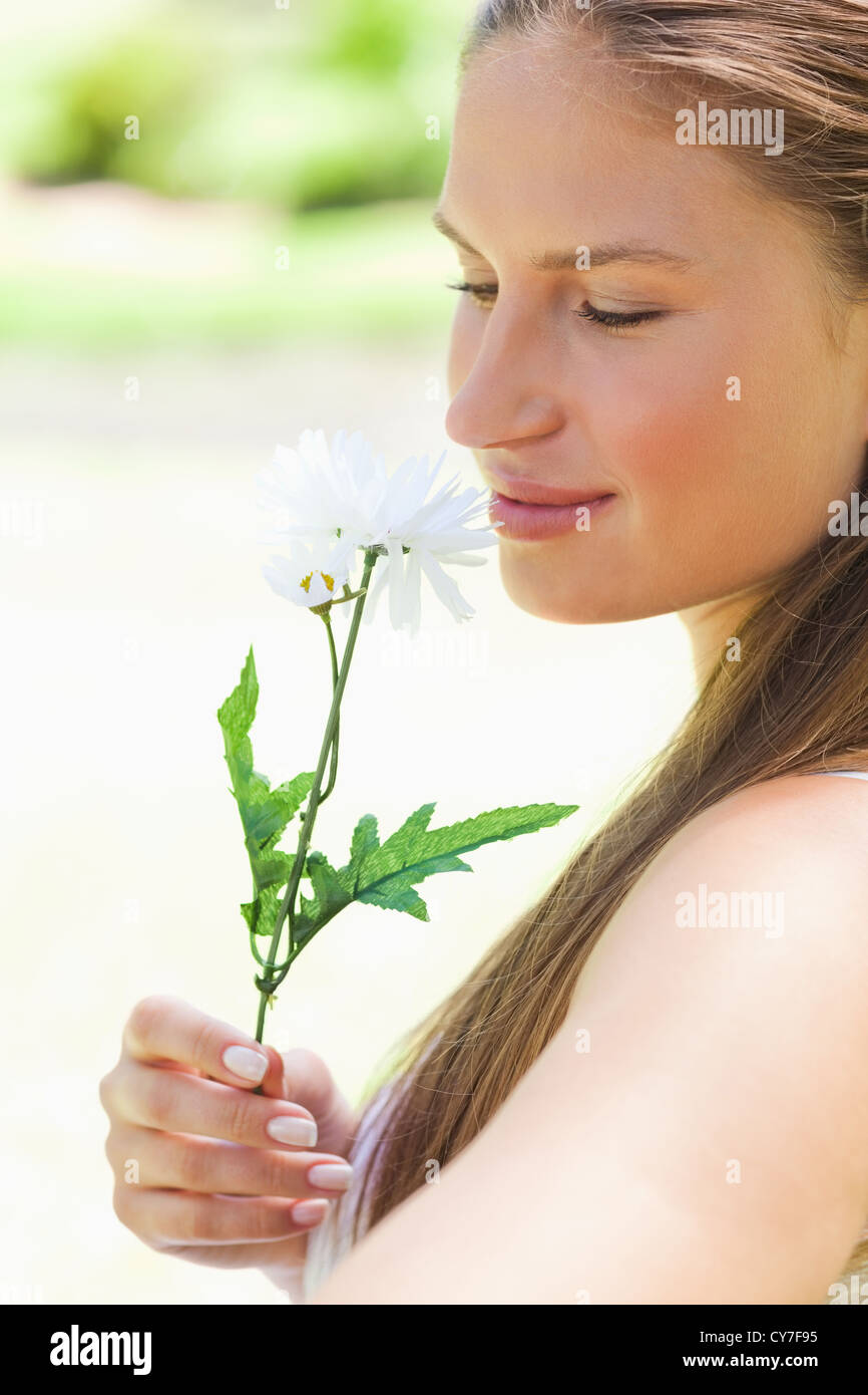 Close up of a woman smelling a flower Stock Photo - Alamy