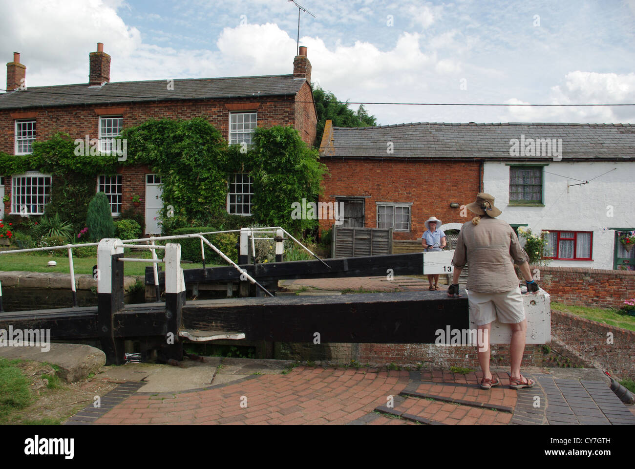 Two holiday-makers opening the lock gates on the Grand Union Canal at Whilton Locks Stock Photo