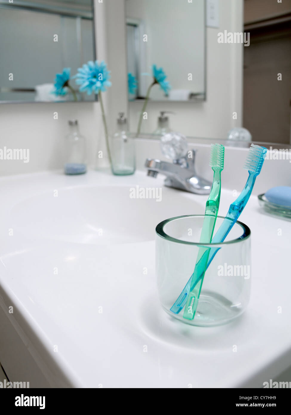 Toothbrushes In Glass In Bathroom Stock Photo
