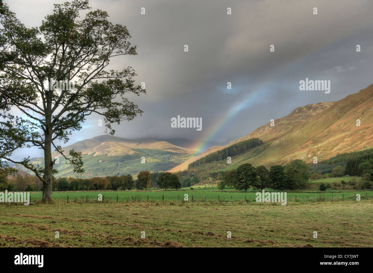 Rainbow across hillside following rain shower. Glen Lyon in Perthshire, Scotland Stock Photo