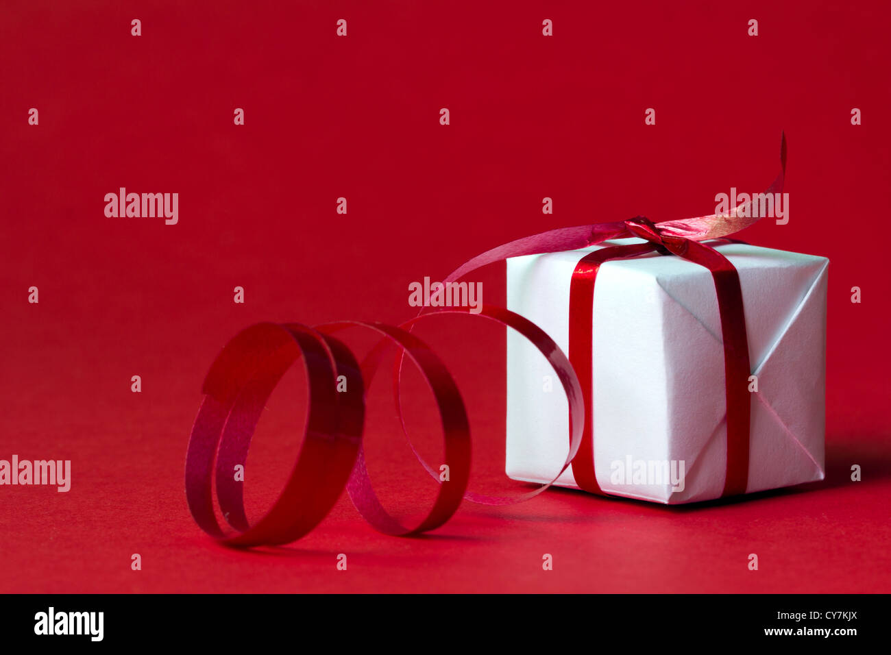 White gift box with red ribbon isolated on red color background Stock ...