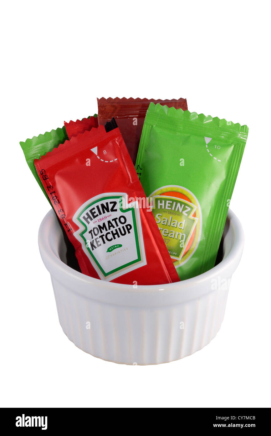 Sachets of Heinz Tomato Ketchup, Salad Cream and Vinegar in a Ramekin Stock Photo