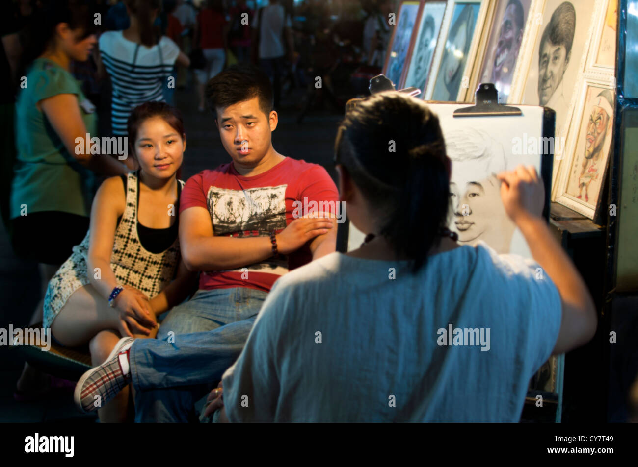 A couple having their portrait drawn on Hefang Old Street, Hangzhou Stock Photo