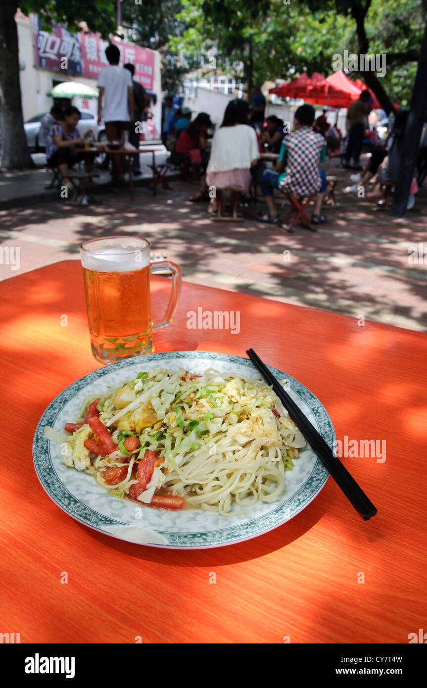 Alfresco dining, Qingdao, China. Fried noodles and Tsingtao Beer. Stock Photo