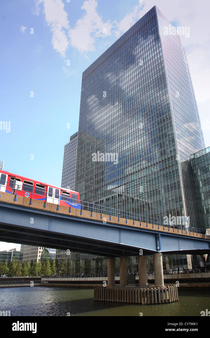 London's Docklands Light Railway (DLR) running between Canary Wharf and Heron Quay stations. 25 Bank street in Background Stock Photo