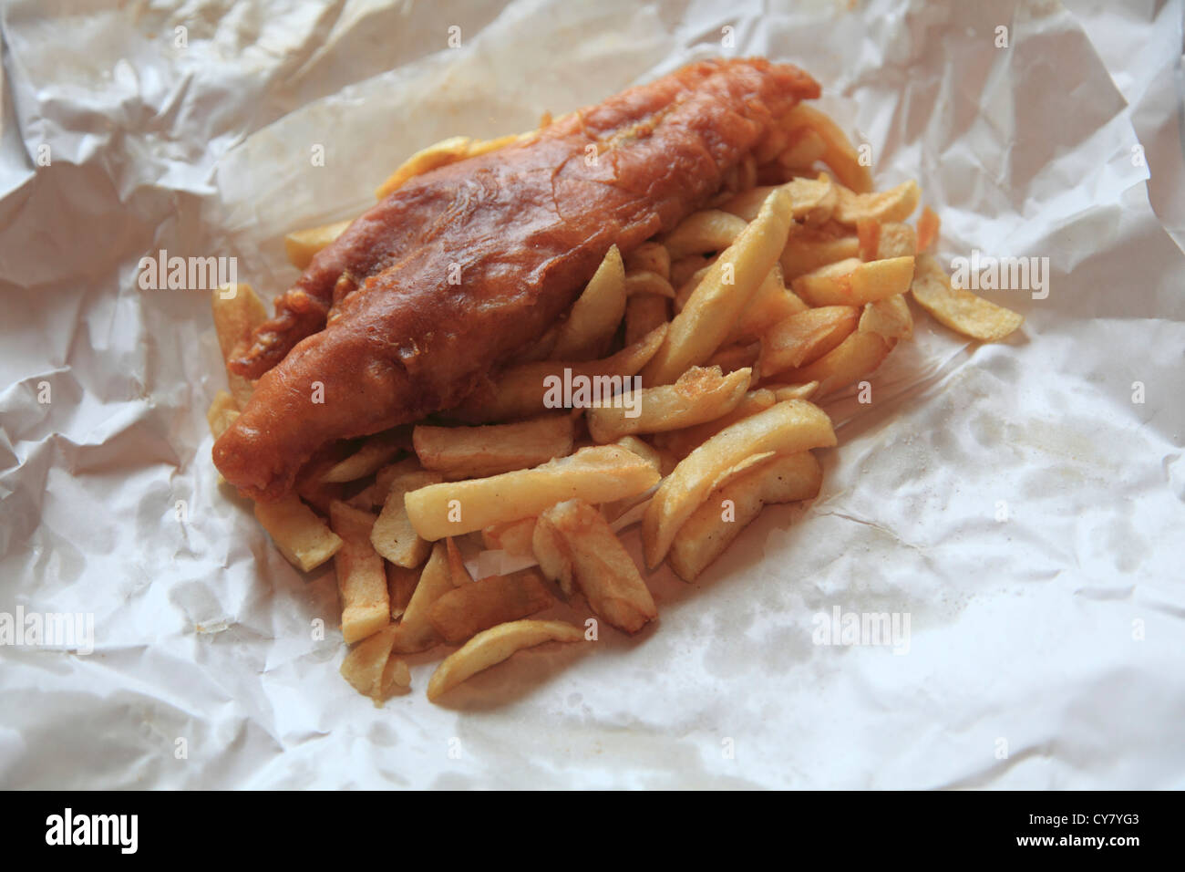Fish and Chips still in paper they are wrapped in when ordered as take away, Great Britain, United Kingdom.  Stock Photo