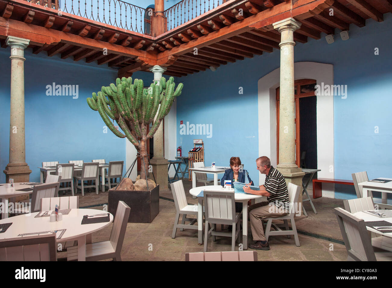 A couple surveys the menu of the restaurant at the Hotel Azul de Oaxaca in the historic downtown of Oaxaca, Mexico. Stock Photo