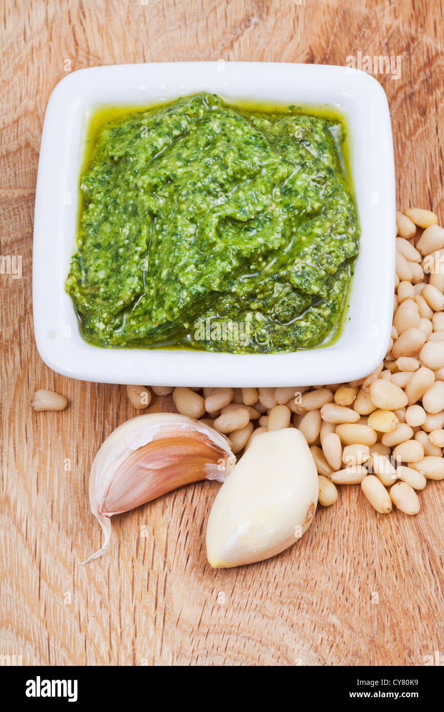 italian pesto sauce with pine nuts and garlic cloves on wooden board