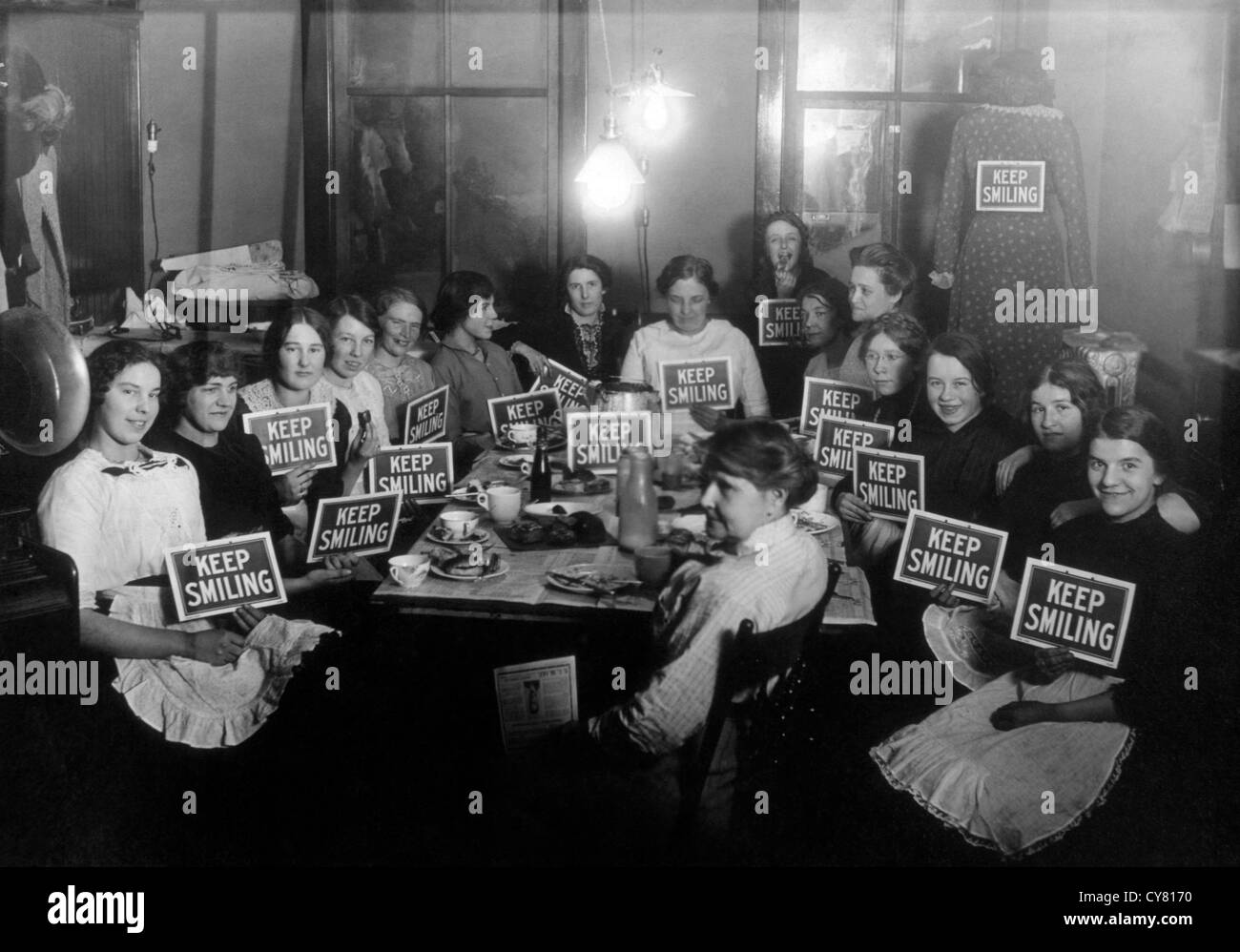 Seamstresses on Lunch Break, Holding Keep Smiling Signs, Circa 1914 Stock Photo