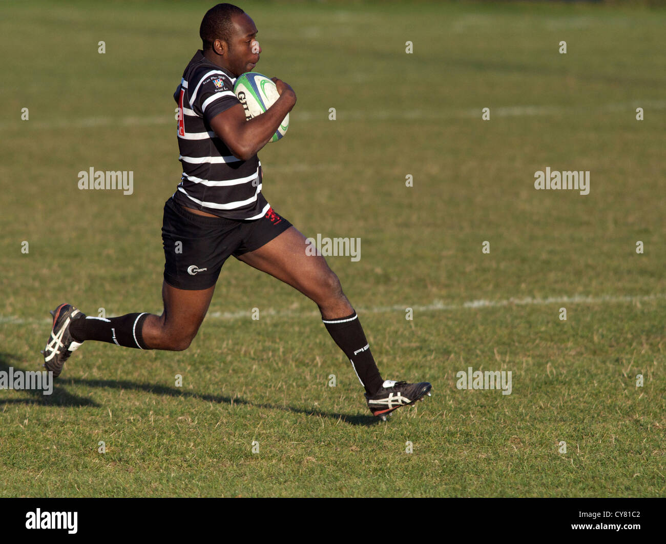 rugby player runs with the ball during a match between Broughton Park and Tyldesley Stock Photo