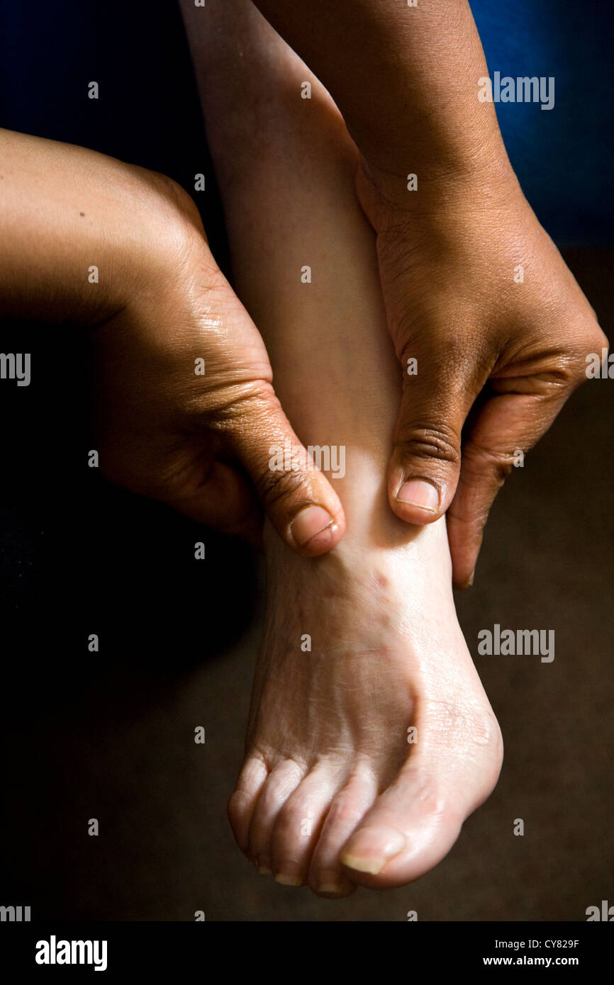 The foot of an old woman being massaged / feet massage on a senior / oap / older woman / person. Stock Photo
