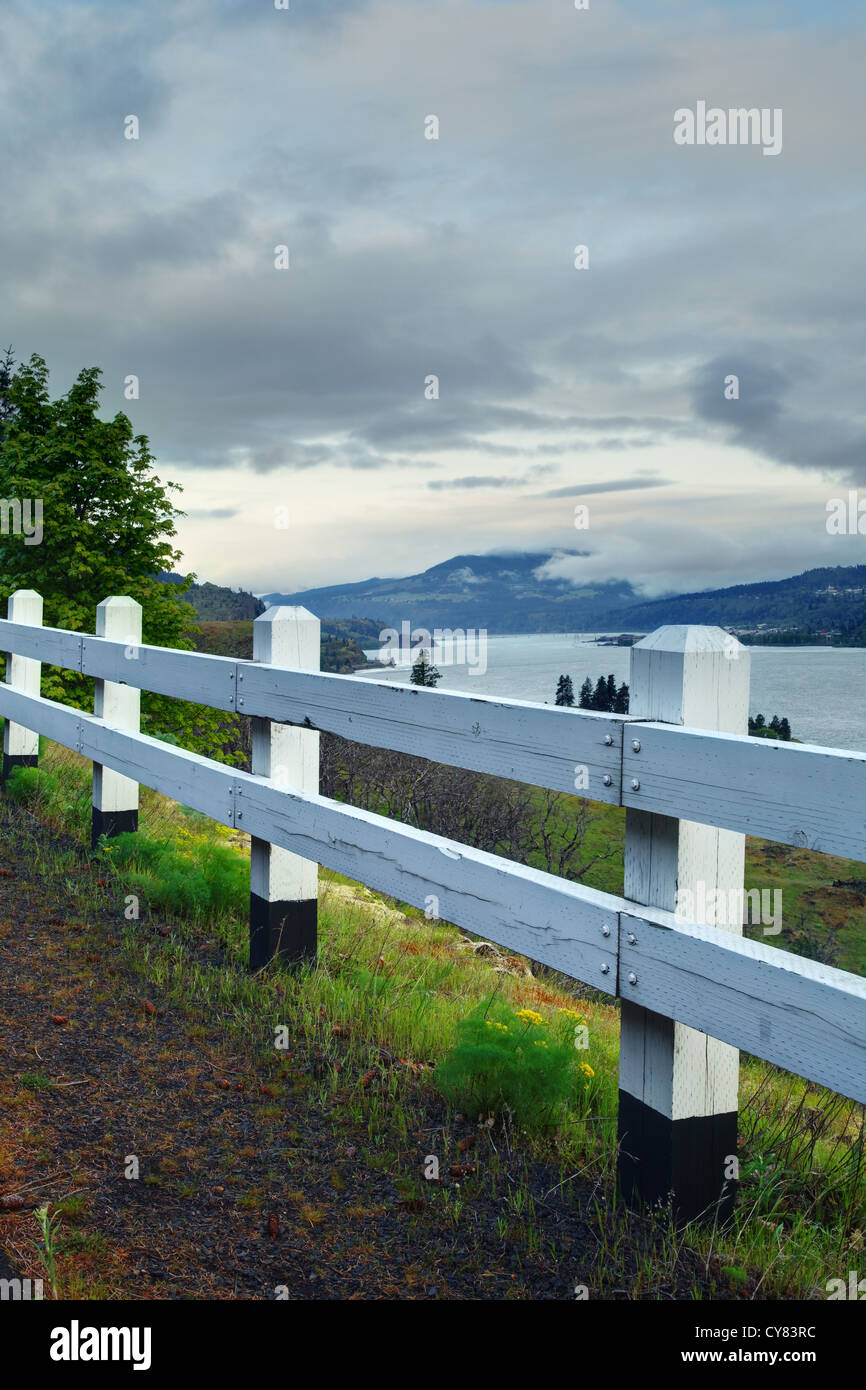 White wooden guard rail overlooking Columbia River along edge of Mosier Twin Tunnels Trail, Mosier, Oregon, USA Stock Photo