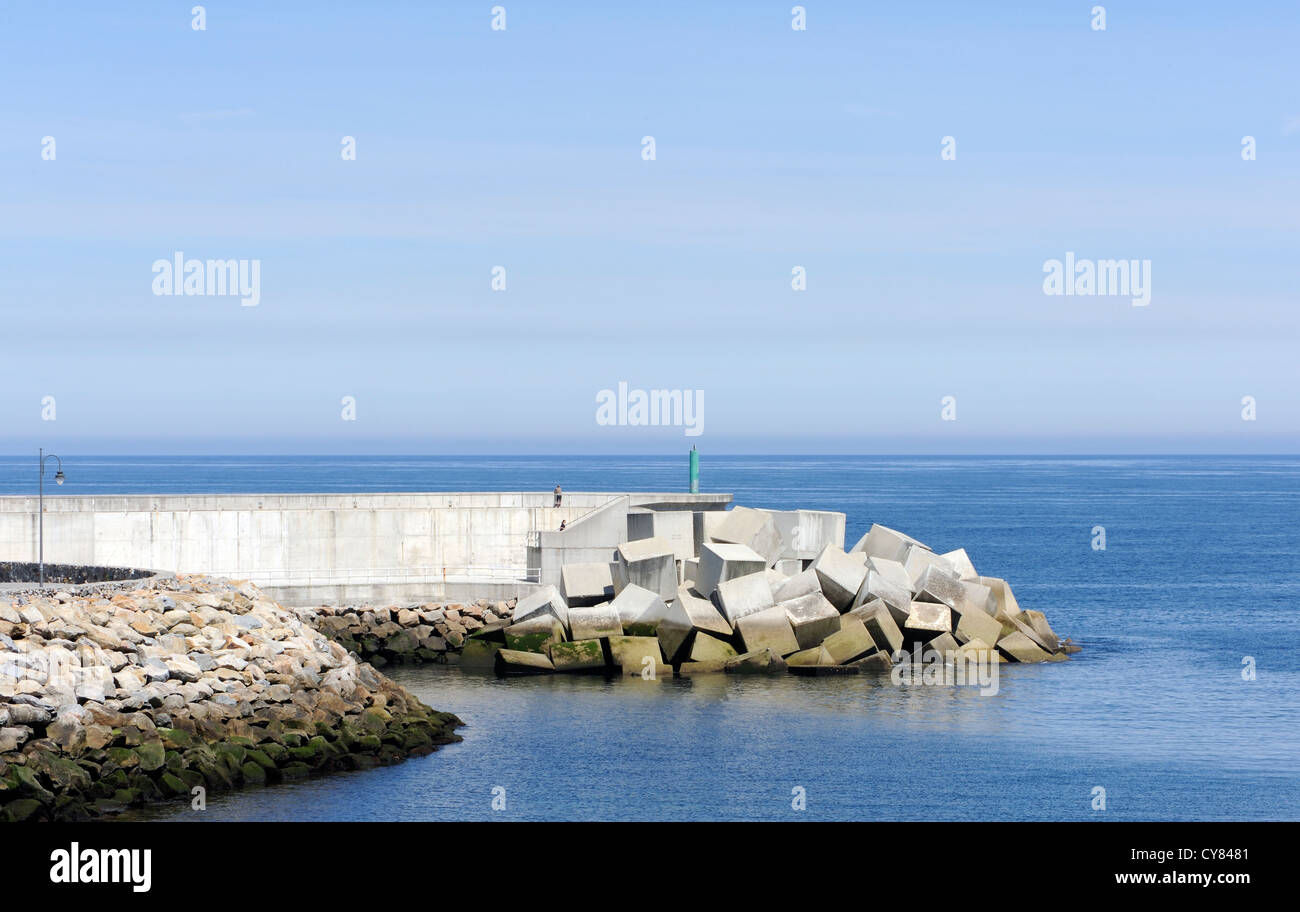 Concrete harbour wall, harbour light and sea defenses protect the harbour from the. Atlantic Ocean. Puerto de Vega, Navia, Stock Photo