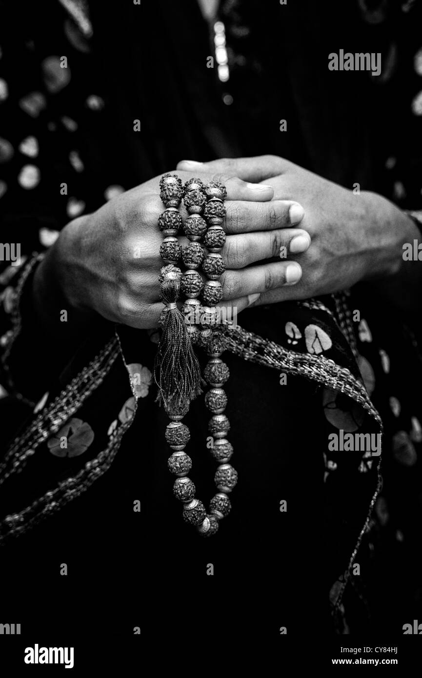 Indian girls hands holding Indian Rudraksha / Japa Mala prayer beads. India. Monochrome Stock Photo