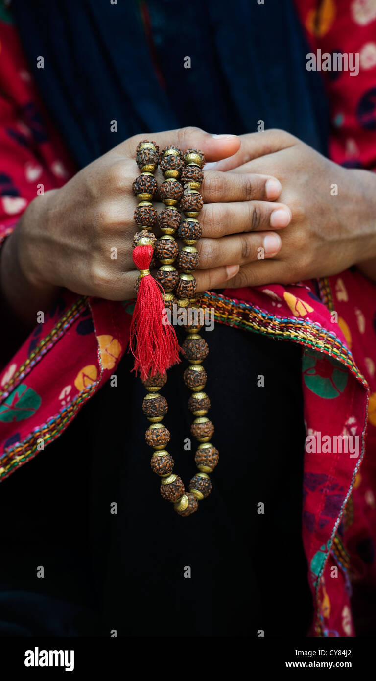 Indian girls hands holding Indian Rudraksha / Japa Mala prayer beads. India Stock Photo