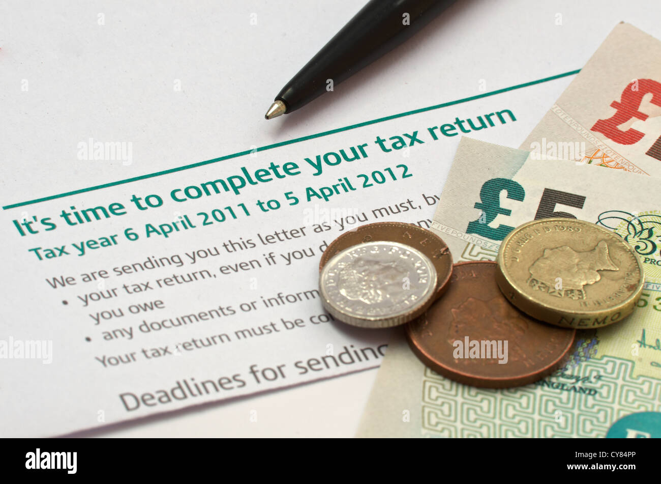 Reminder Letter that it is time to complete a tax return. On the letter is a pen and british Sterling currency Stock Photo