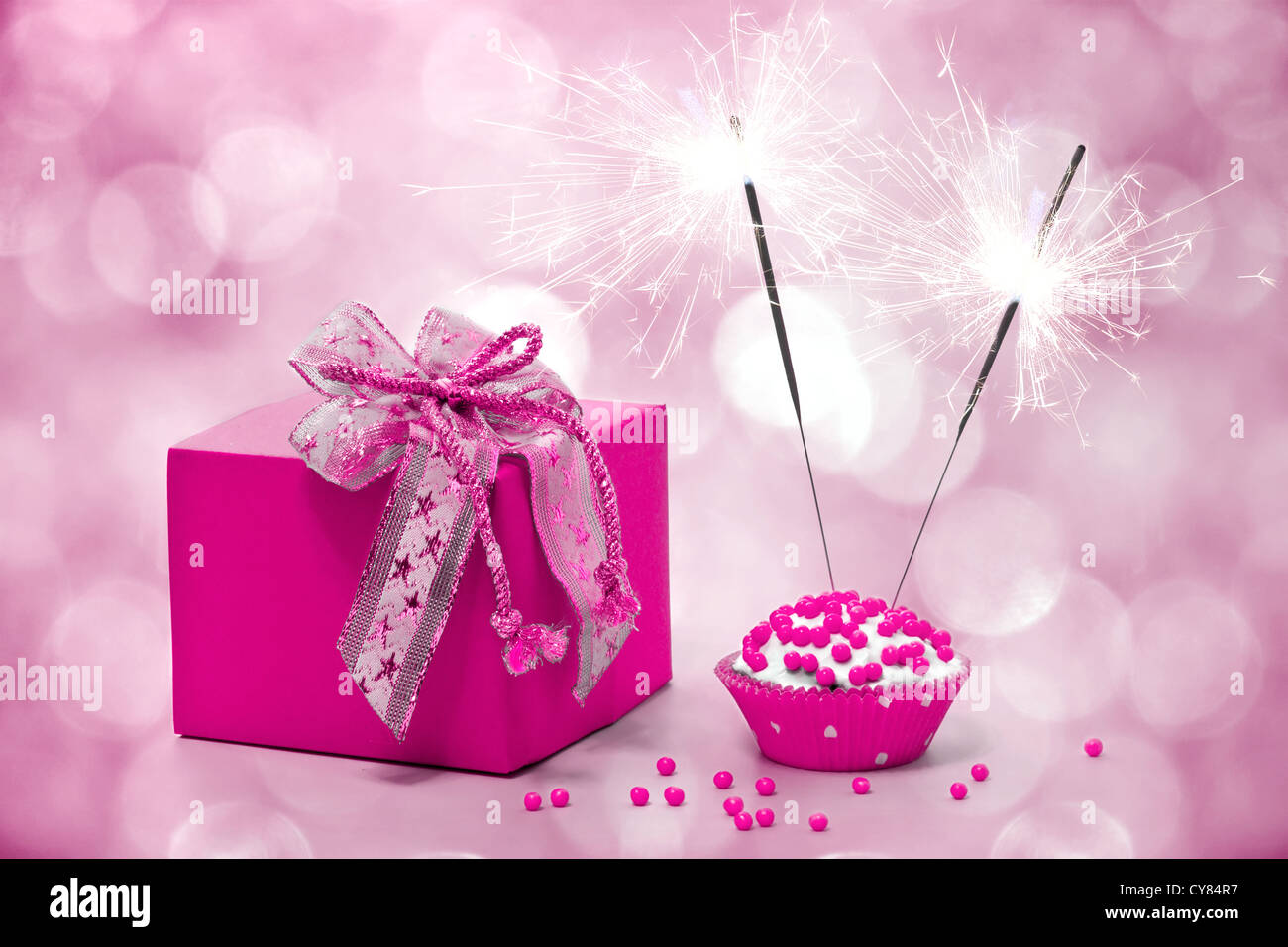 birthday cake with sparkler and gift on a pink background Stock Photo ...