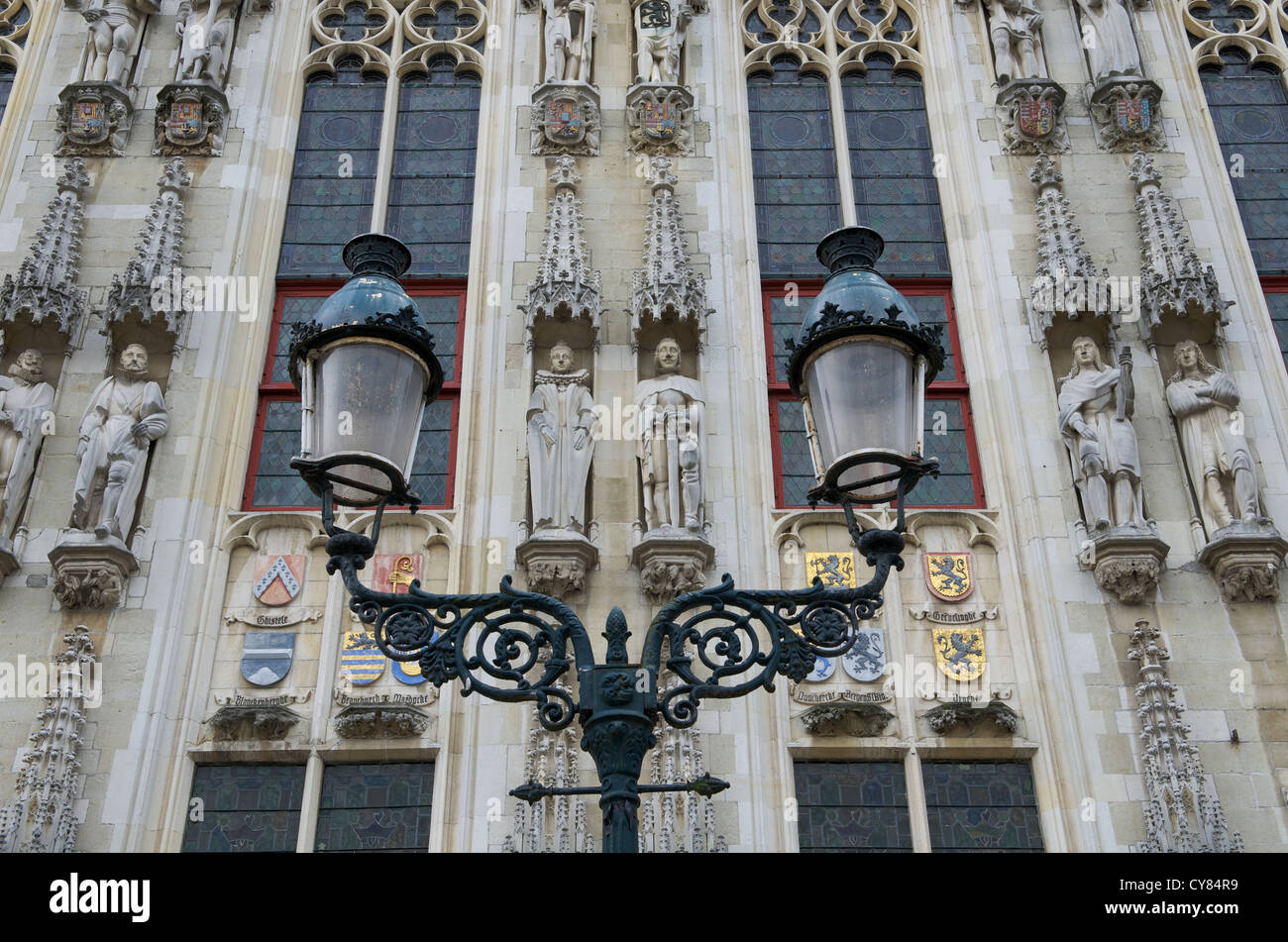 Facade of the old Town Hall (Burg) in Brugge, Belgium. Looking upward with statues framed by the lamp post Stock Photo