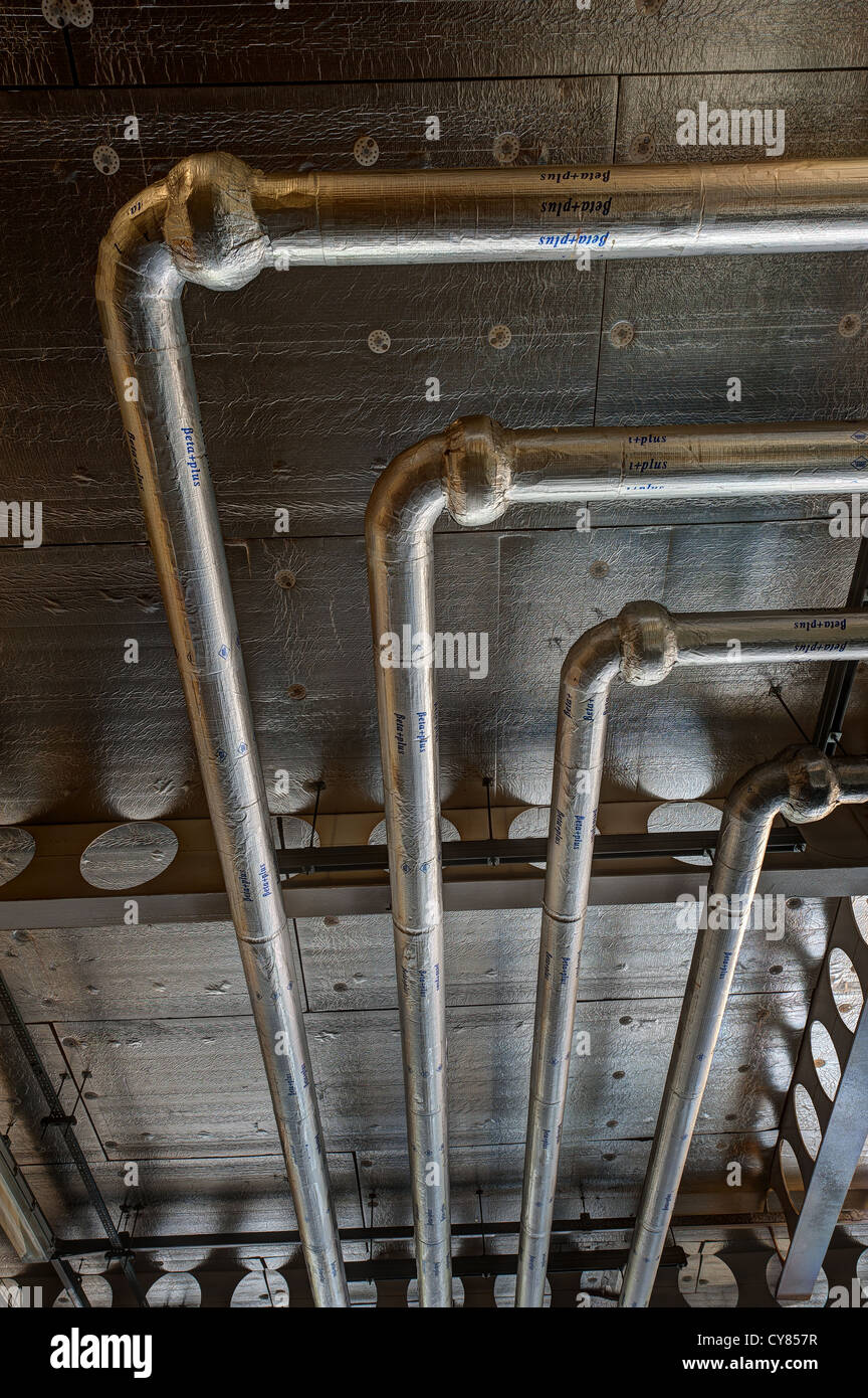 Clean industrial air conditioning and water systems insulated in ground floor space to modern office building Stock Photo