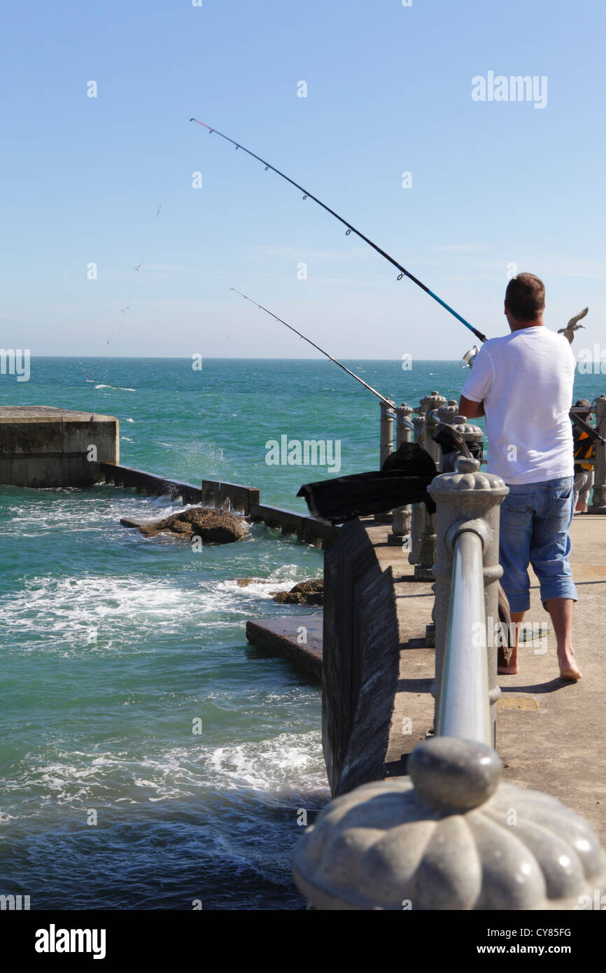 Man fishing on the harbour arm at Hastings East Sussex UK GB Stock Photo