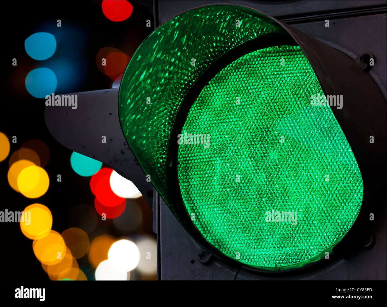 Green traffic light with colorful unfocused lights on a background Stock Photo