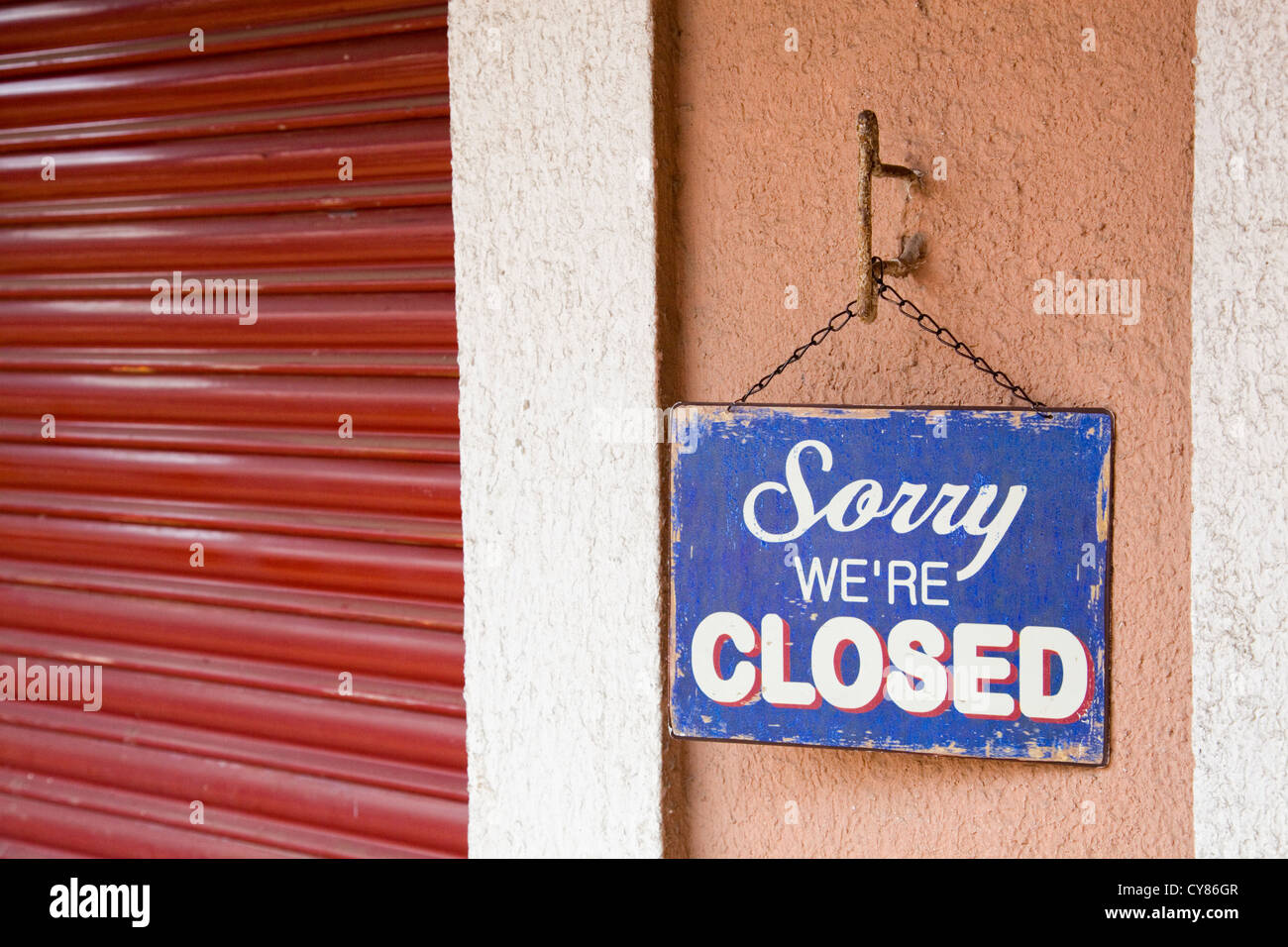 Vintage metal closed sign next to a closed blind, as a concept of crisis Stock Photo