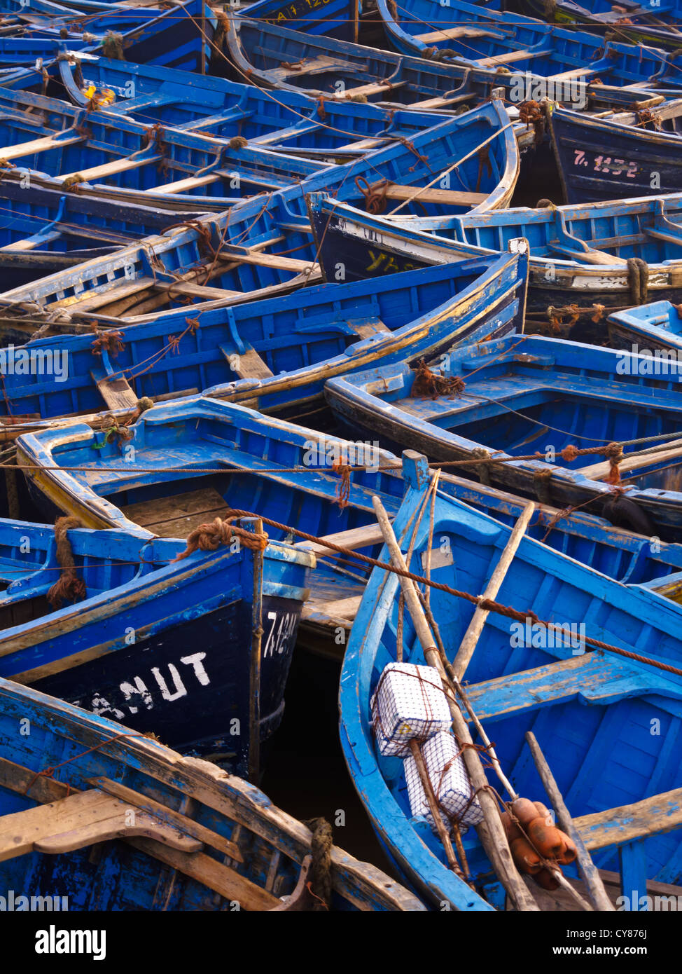 Fleet of blue wooden fishing boats tied together in the harbor in  Essaouira, Morocco. Stock Photo