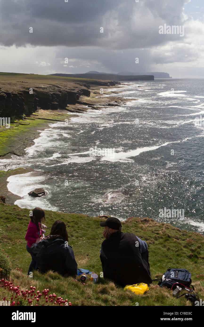 Family having a rest on a coastal walk on Orkney islands Stock Photo