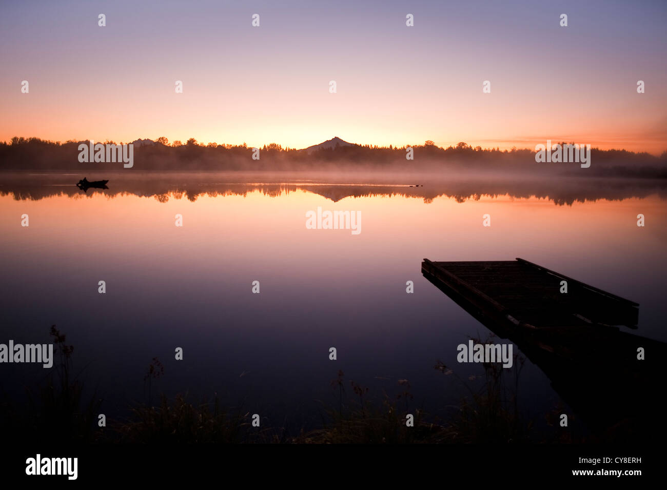 Sunrise in fog Lake Cassidy with dock along shoreline with Mount