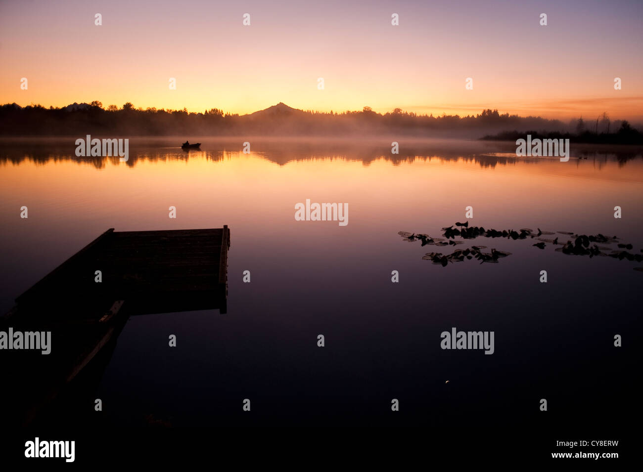 Sunrise in fog Lake Cassidy with dock along shoreline with Mount